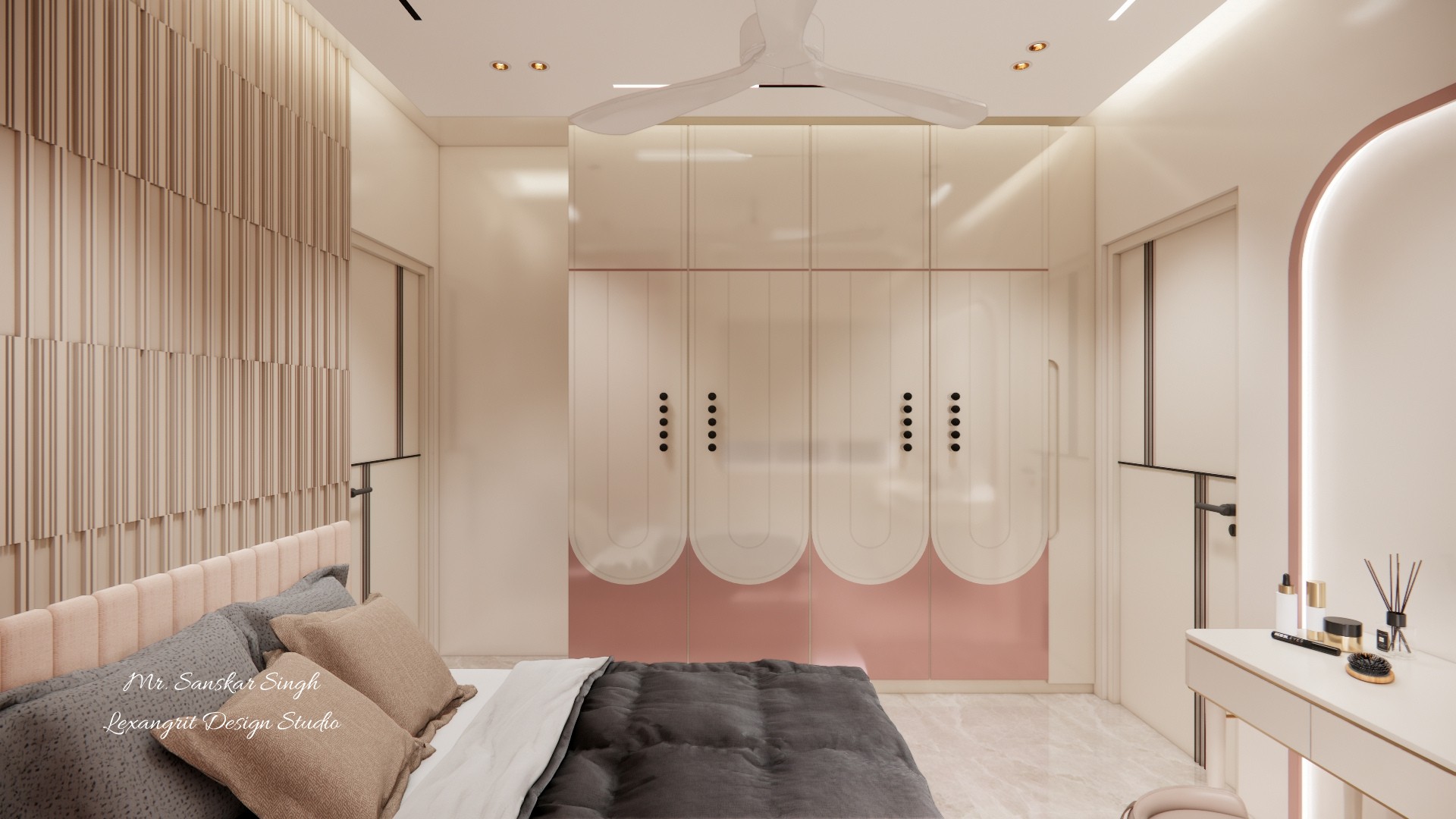 Blush and cream bedroom with a dark-covered bed, ribbed headboard wall, curved wardrobe fronts, dressing table, arched mirror, and ceiling fan.