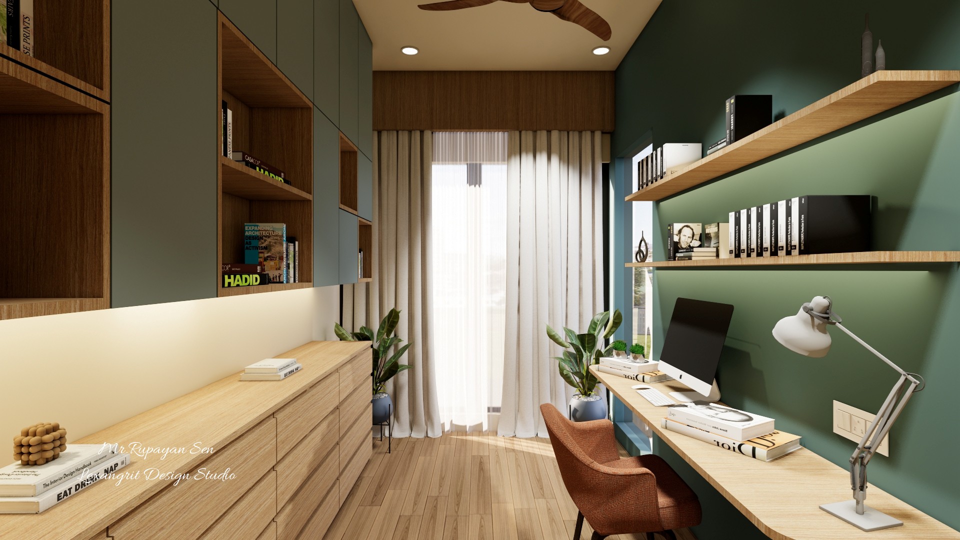 Home office corner with long timber desk, green wall shelving, drawers, and a bright curtained window.