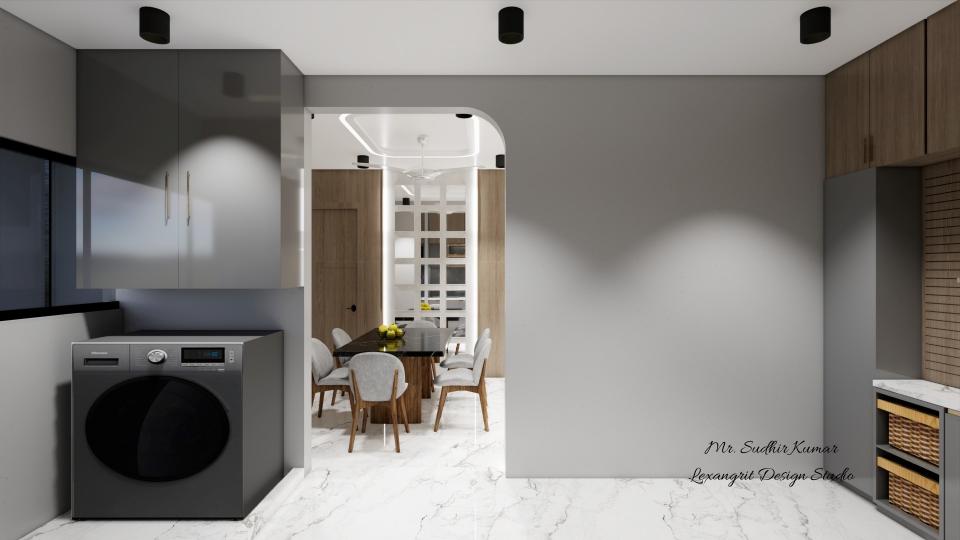 A modern kitchen laundry area featuring a dark grey front-loading washing machine under glossy grey upper cabinets, with a view through an arched doorway into a dining room with wooden chairs and a table.