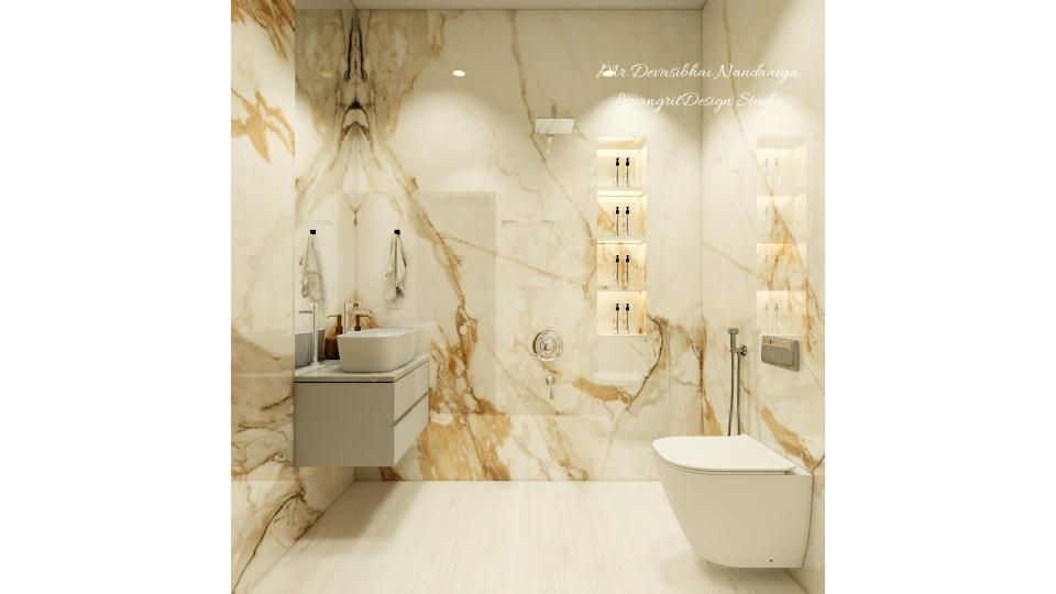 guest bathroom with full wall tiles of white and gold italian marble texture with glossy finish,for flooring cream vitrified tiles are used , beside shower we can see a niche storage,on left wall counter top wash basin with mininal vanity unit of WPC with grey laminate finish,on right wall Wc is placed in form of space management & cluster free design.